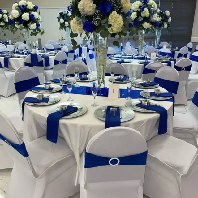 Wedding reception with royal blue sashes and tall floral centrepieces